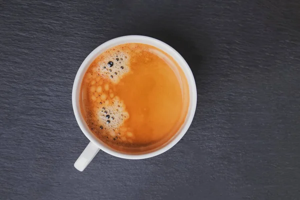 Xícara de café fresco na mesa preta — Fotografia de Stock