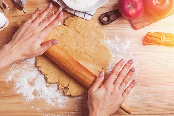 Жіночі руки розкачують тісто для яблучного пирога — стокове фото