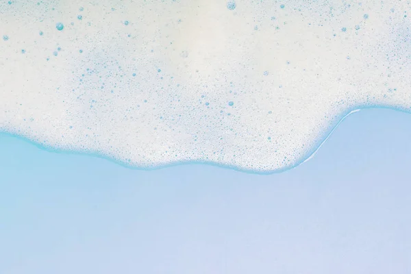 Schiuma bianca su sfondo blu pastello — Foto Stock