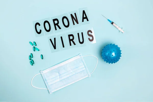 Αφηρημένο μοντέλο στελέχους ιού της νόσου του Coronavirus Covid-19, χάπια, σύριγγα και μάσκα σε μπλε χρώμα με χώρο αντιγραφής. — Φωτογραφία Αρχείου
