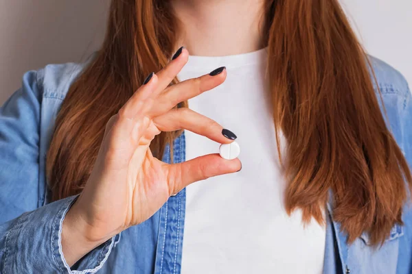 Gros plan de la main des femmes tenant une pilule blanche — Photo