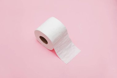 Pembe arka planda tuvalet kağıdı rulosu.