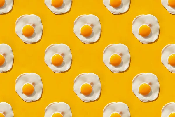 Жареные яйца на желтом фоне — стоковое фото