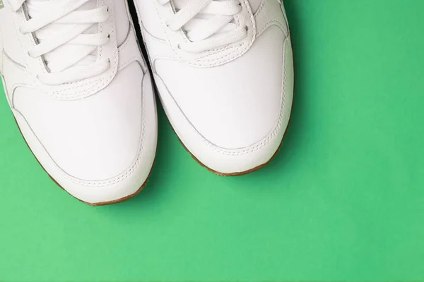 Λευκά γυναικεία αθλητικά παπούτσια απομονωμένα σε πράσινο φόντο. — Φωτογραφία Αρχείου