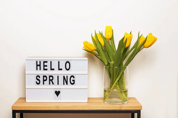 Hallo Voorjaarstekst op een display lichtbak met gele tulpen — Stockfoto