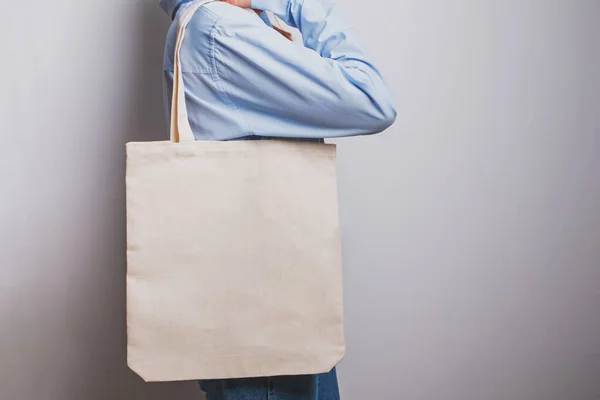 Girl in blue shirt holds blank cotton eco tote bag, — Stock Photo, Image