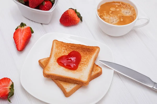 Rostat bröd och sylt i hjärtform, jordgubbar och kaffe — Stockfoto