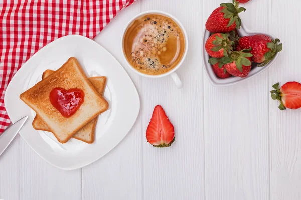 Pane tostato e marmellata a forma di cuore, fragole e caffè — Foto Stock