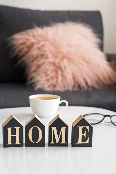 Wooden letters Home on small table with blurred living room on the background. Cozy home, stay home concept — Stock Photo, Image