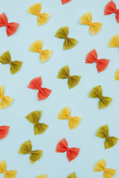 Suche kolorowe włoski makaron farfalle lub łuki na niebieskim tle — Zdjęcie stockowe