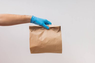 Koruyucu eldiven takan ve maske takan bir kurye.