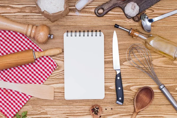 Papel de bloc de notas en blanco para texto o recetas y utensilio de cocina sobre mesa de madera —  Fotos de Stock