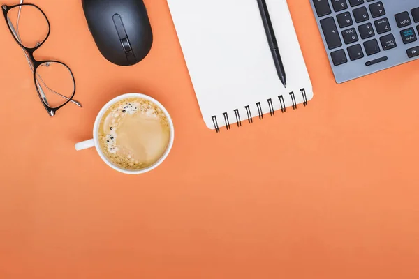 Gult skrivbord kontor med laptop, mus och andra arbetsförnödenheter med kopp kaffe. — Stockfoto