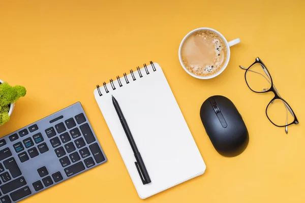 Клавиатура, компьютерная мышь и кофе на желтом фоне — стоковое фото