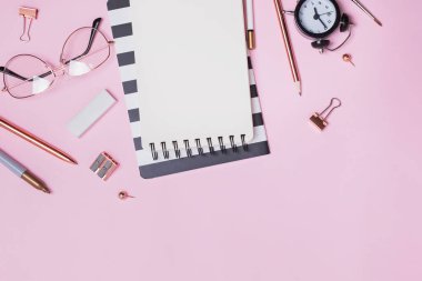 Pembe arka planda kırtasiye malzemeleri ve ofis malzemeleri var.