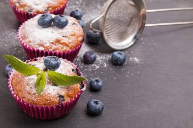 Lezzetli yaban mersinli kekler krema şekeri ile pudralanmış.