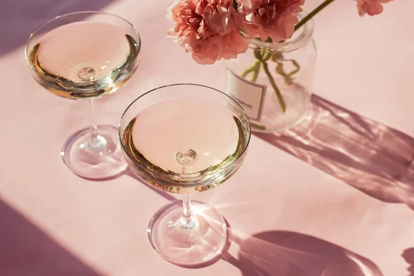 Dois copos de vinho espumante na mesa rosa — Fotografia de Stock