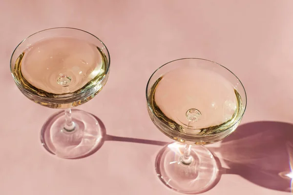 Dois copos de vinho espumante na mesa rosa — Fotografia de Stock
