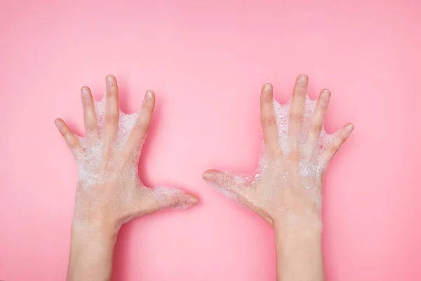 Mãos femininas com espuma borbulhante sabão no fundo rosa , — Fotografia de Stock