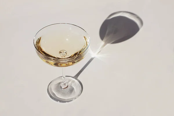 Two glasses of sparkling wine on the pink table in natural sunlight with shadows. — Stock Photo, Image