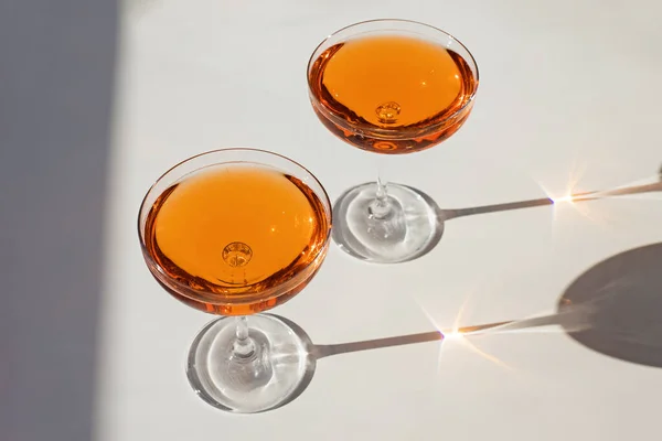Дві склянки коктейлю з ігристим вином на білому столі в природному сонячному світлі — стокове фото