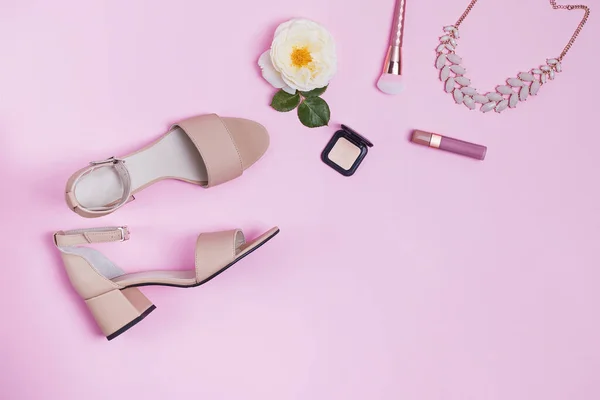 Composición con sandalias y accesorios para mujer sobre fondo rosa . — Foto de Stock