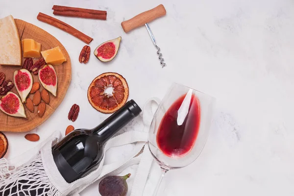 Composição flat lay com garrafa e copo de vinho tinto e diferentes lanches — Fotografia de Stock