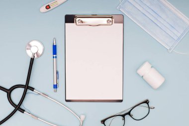 Stetoskop, tıbbi maske, gözlük ve diğer objelerle yatıyordu