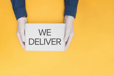 Kuryeler koruyucu eldivenler içinde ellerinde karton bir kutu taşıyorlar.