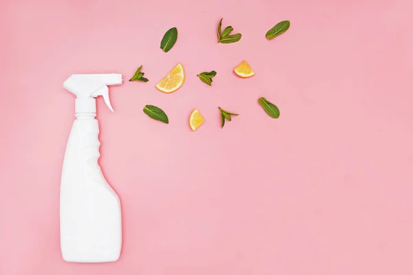 Mosószer spray palack rózsaszín alapon friss mentalevéllel és citromszeletekkel. — Stock Fotó