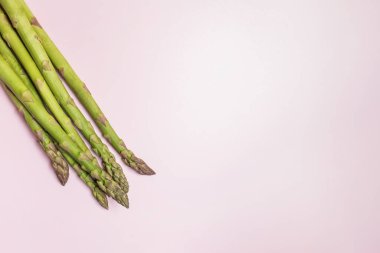 Pembe arka planda yeşil mevsimlik kuşkonmaz, renkli bir kuşkonmaz.