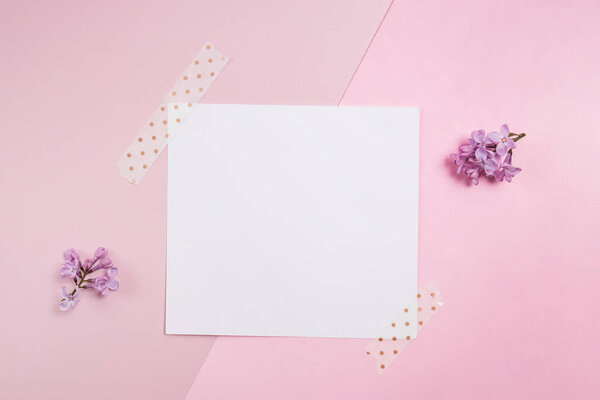 Empty card on pink background with small lilac flowers