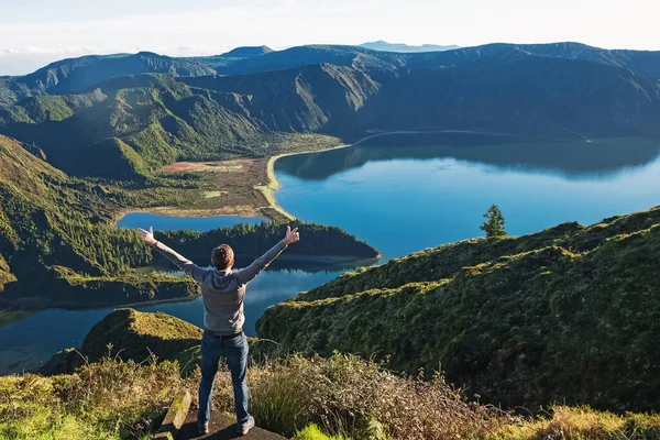 Człowiek podróżnik stojący z widokiem na górskie jezioro — Zdjęcie stockowe