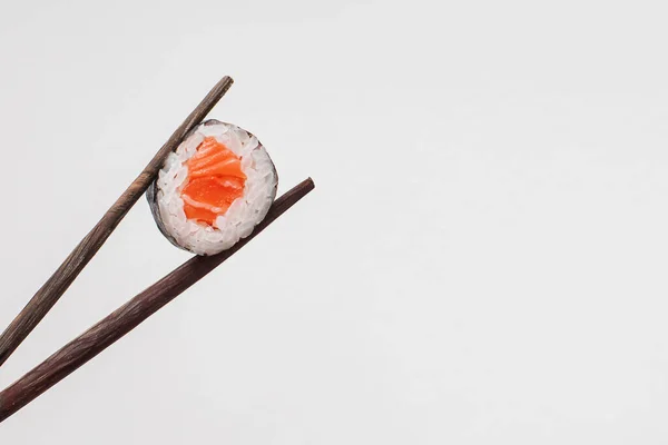 Sushi em paus de madeira pretos em um fundo branco — Fotografia de Stock