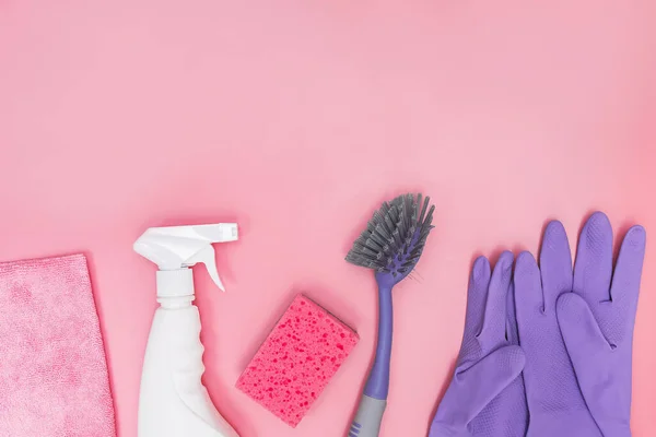 Cleaning tools and supplies on pink background