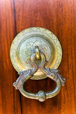 Eski ahşap girişin antika kapı kolu.