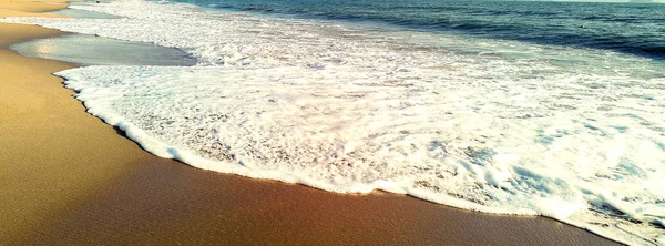 Playa de arena con espuma al atardecer — Foto de Stock