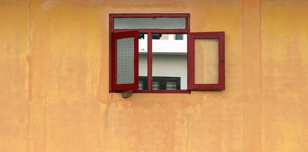 Fenêtre rouge en façade de maison jaune — Photo