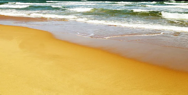 Morbide onde con schiuma blu oceano mare spiaggia sabbiosa — Foto Stock