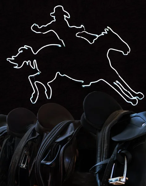 Neon cowboy lights glowing on the wall Rider Leather Saddles — Stock Photo, Image