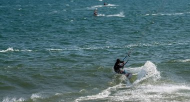 Dalgalardaki uçurtmacılar deniz suyu sıçratır, çekici spor denizleri. Mui! 