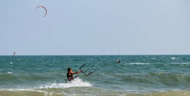 Dalgalardaki uçurtmacılar deniz suyu sıçratır, çekici spor denizleri. Mui! 