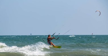 Dalgalardaki uçurtmacılar deniz suyu sıçratır, çekici spor denizleri. Mui! 