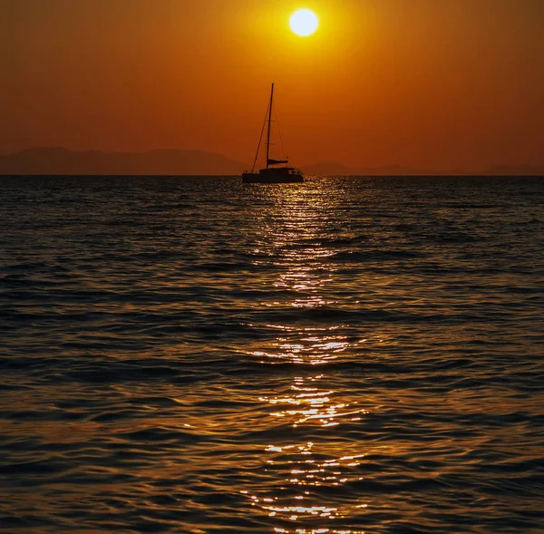 Larga cola barco sol luz dorada puesta del sol fondo — Foto de Stock