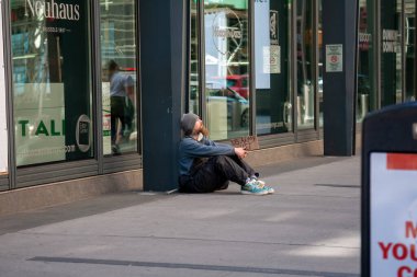 New York, ABD - 2 Mayıs 2020: Sokakta oturan evsiz bir adam yardım istiyor 