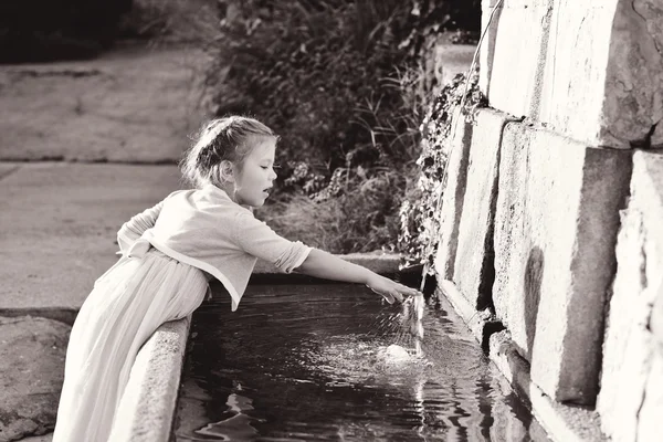 Meisje in de buurt van de fontein — Stockfoto