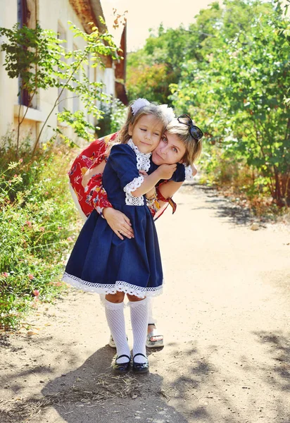 Kleines Schulmädchen mit Mutter — Stockfoto