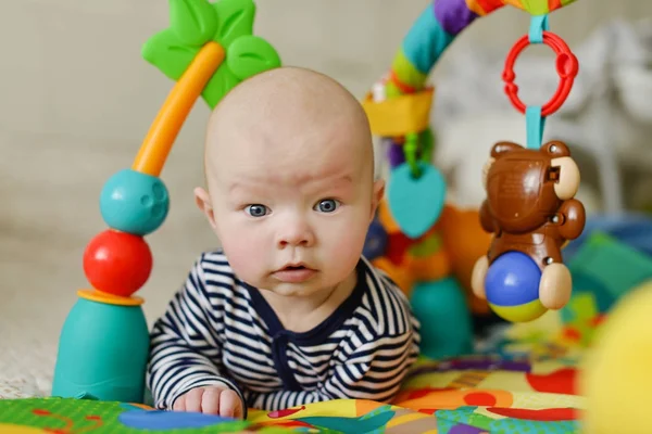 Bebé en la alfombra de juguete —  Fotos de Stock
