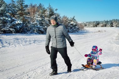 Baba ve kışın karda oynayan kız