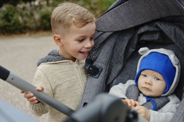Bebek oğlan ve küçük oğlan yürüyüşe çıktılar.